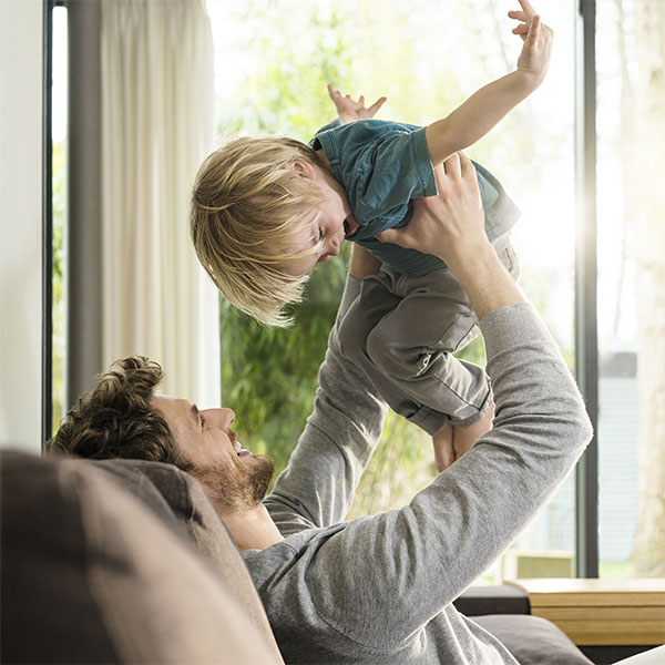 Dad playing with son on couch